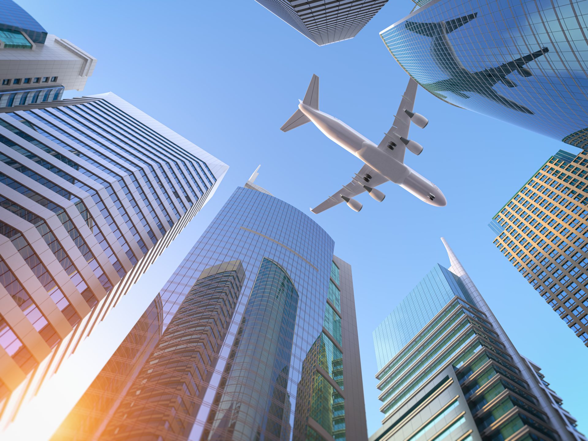 Airplane flying above modern skyscrapers in a bustling downtown business district.