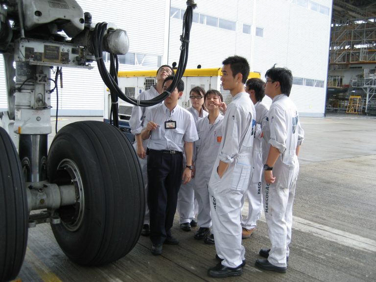 Group of technicians examining aircraft landing gear in hangar