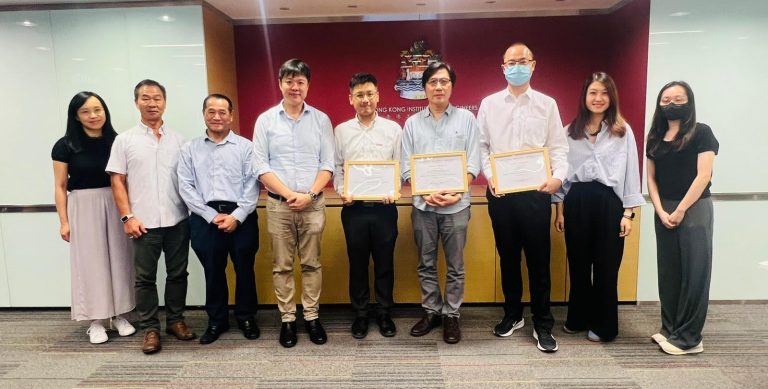 Group of people posing with framed certificates in front of Hong Kong Institution of Engineers logo