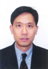 Portrait of a man in a suit and tie against a plain background.