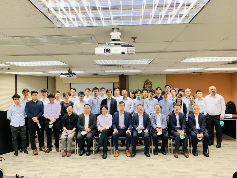 Group photo of attendees at a business meeting in a conference room.