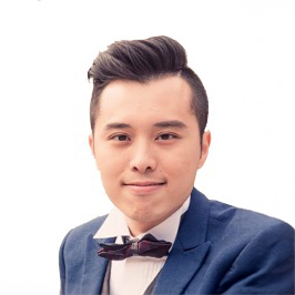 Man in blue suit and bow tie smiling at camera