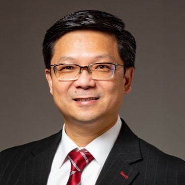 Portrait of Jonathan LEE, wearing glasses, suit, and red tie.