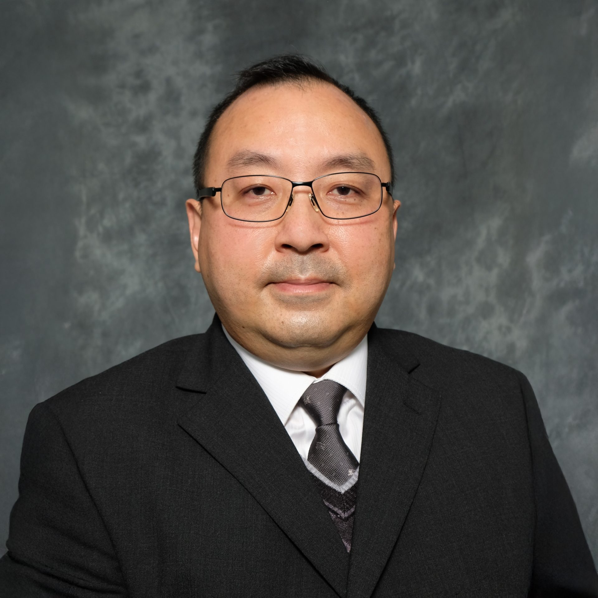 Man in suit and glasses, professional headshot
