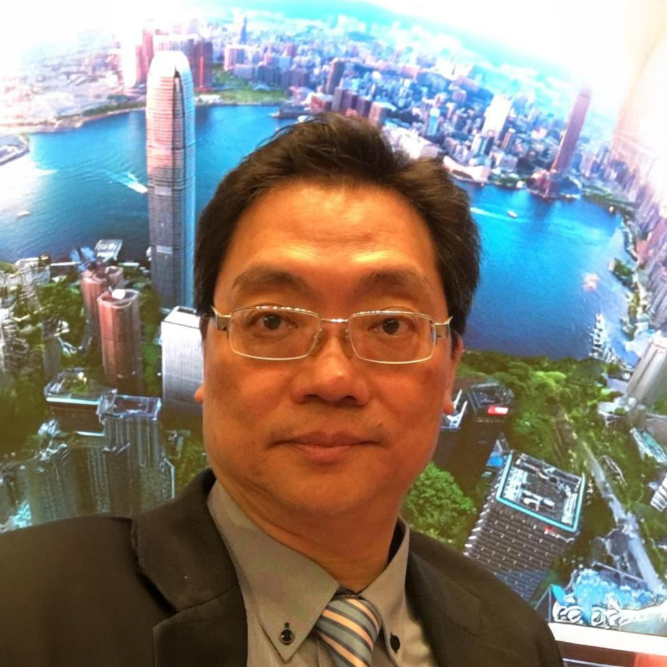 Man in suit and glasses with Hong Kong skyline background