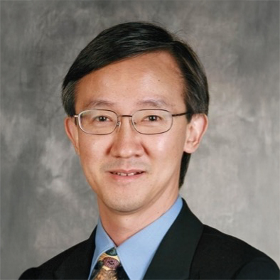 Portrait of a smiling man with glasses wearing a suit and tie.