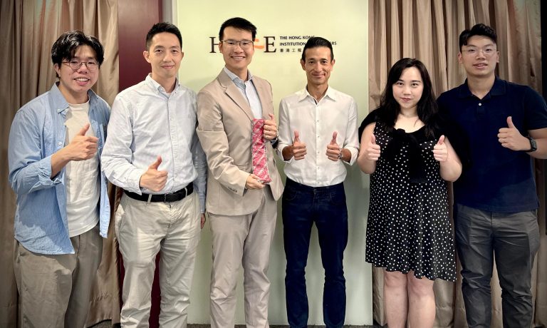 Six people posing with thumbs up in front of Hong Kong Institution of Engineers logo