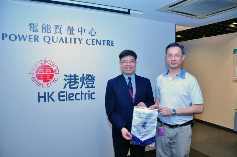 Two men holding a banner at HK Electric's Power Quality Centre.