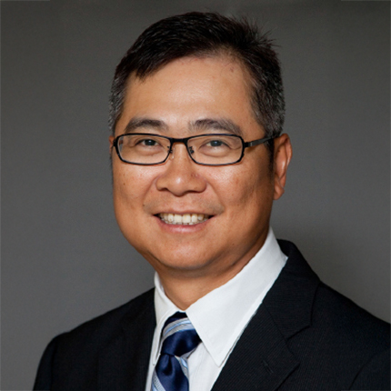 Smiling man with glasses wearing suit and tie