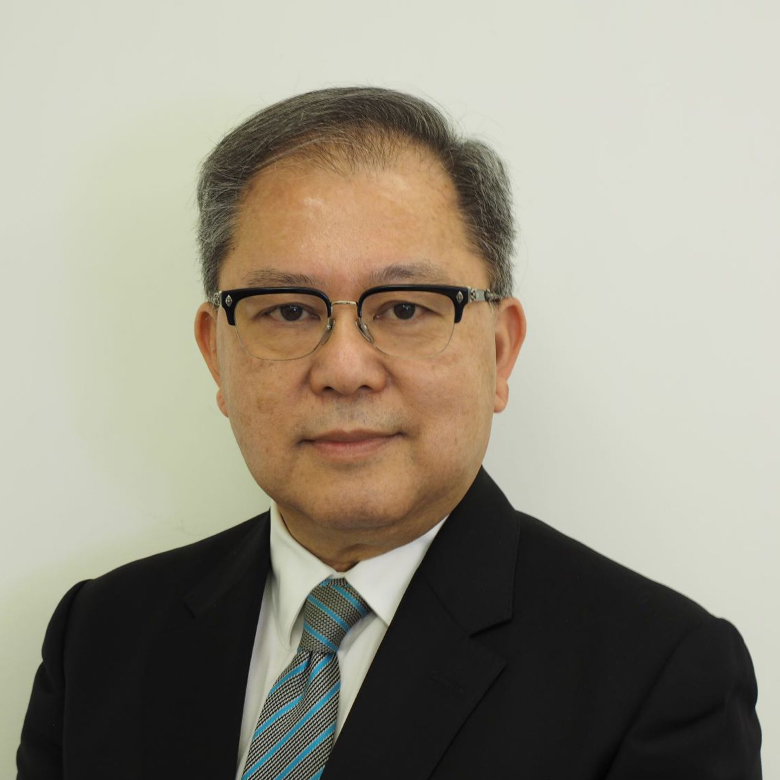 Man in black suit and glasses with blue striped tie