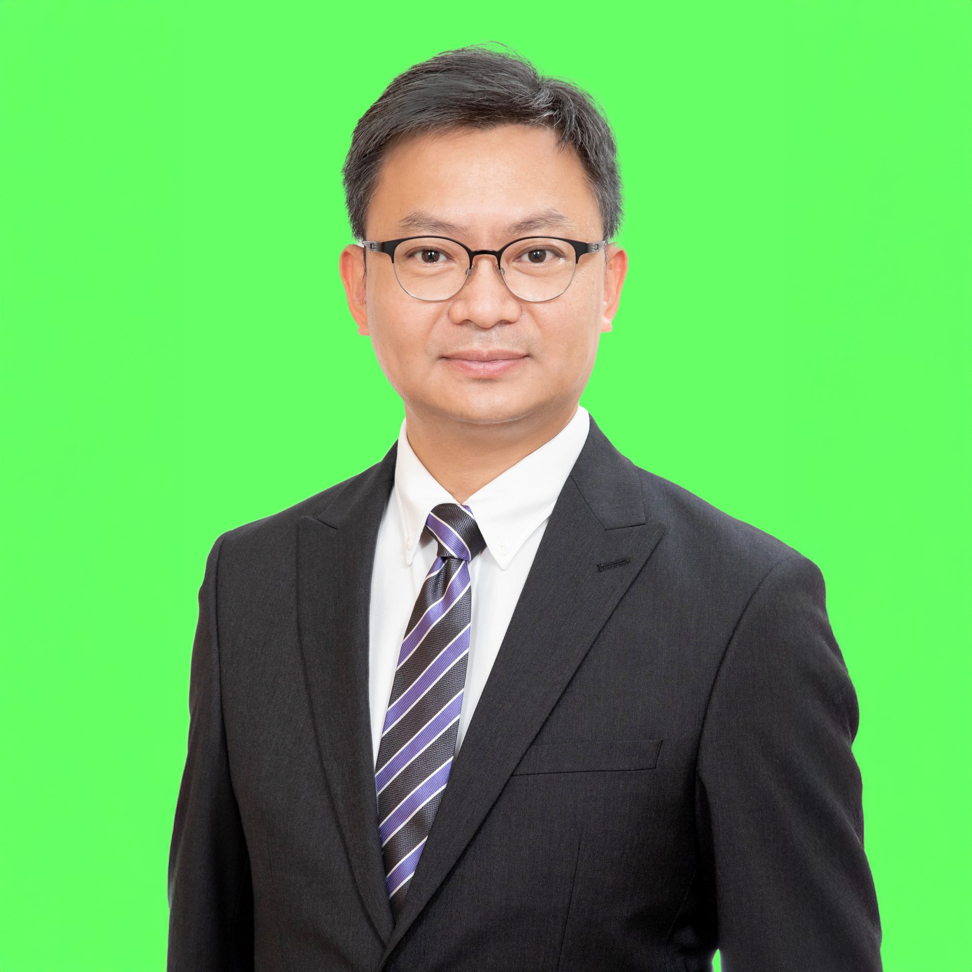 Man in suit and glasses against green background