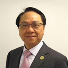 Portrait of a man in suit and glasses, smiling at camera