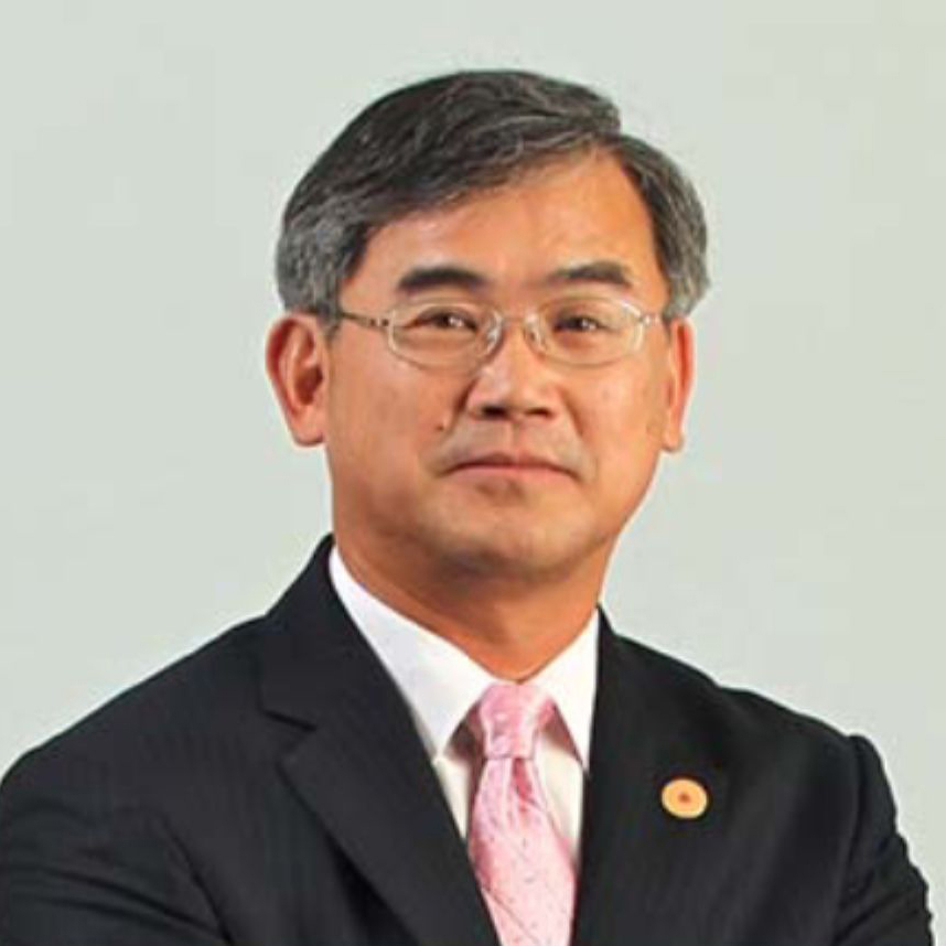Portrait of a man with glasses wearing a suit and pink tie.