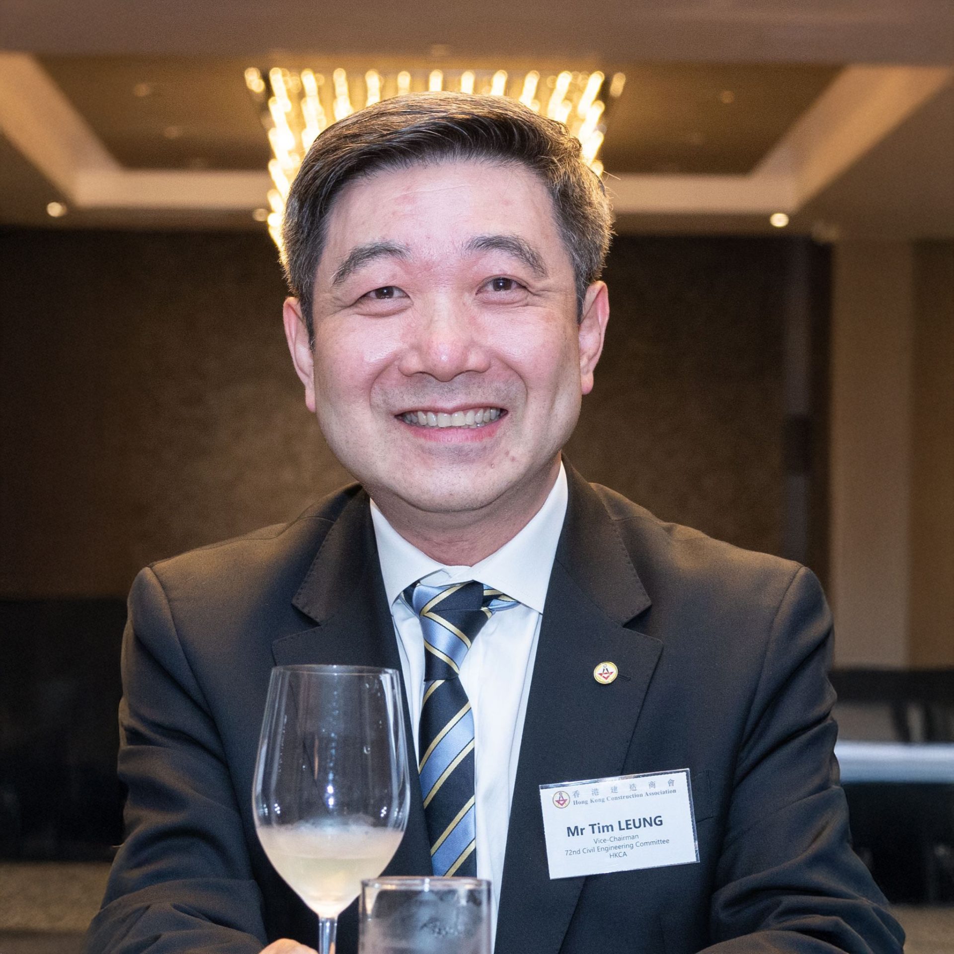 Mr. Tim Leung, Vice-Chairman, smiling at event with wine glass