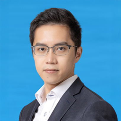 Man with glasses and dark suit against blue background