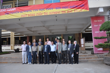 Group of people posing for photo under banner for computer science olympiad event