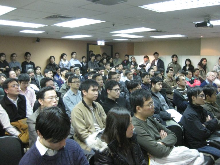 Audience seated in conference room listening attentively to presentation
