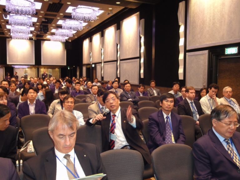 Audience at conference listening to speaker with microphone