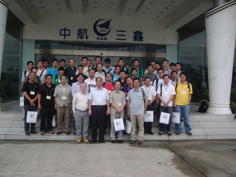 Group of people posing for photo in front of AVIC CAS building entrance