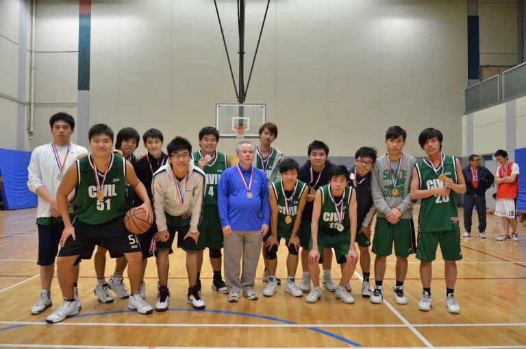 Basketball team with medals posing for photo on court