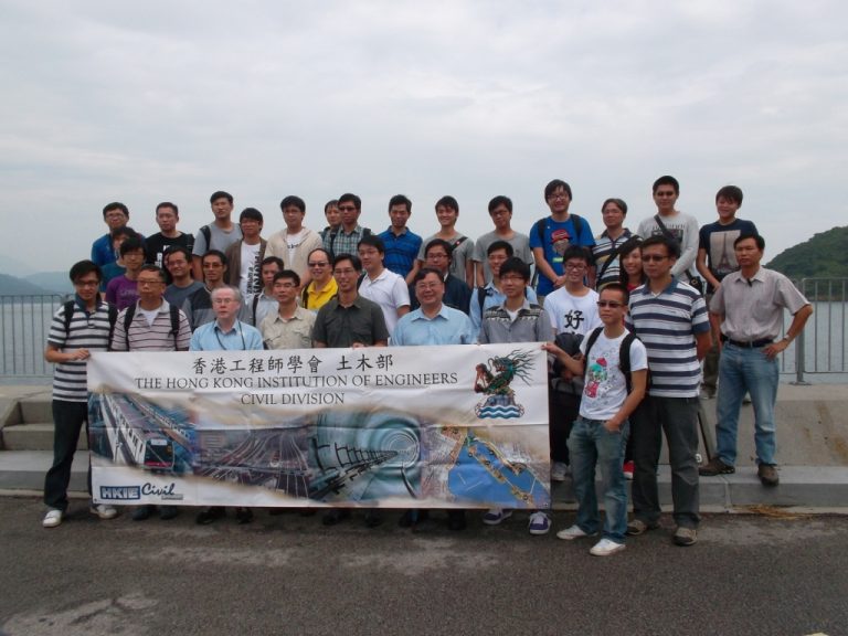 Group of civil engineers posing with HKIE Civil Division banner outdoors.