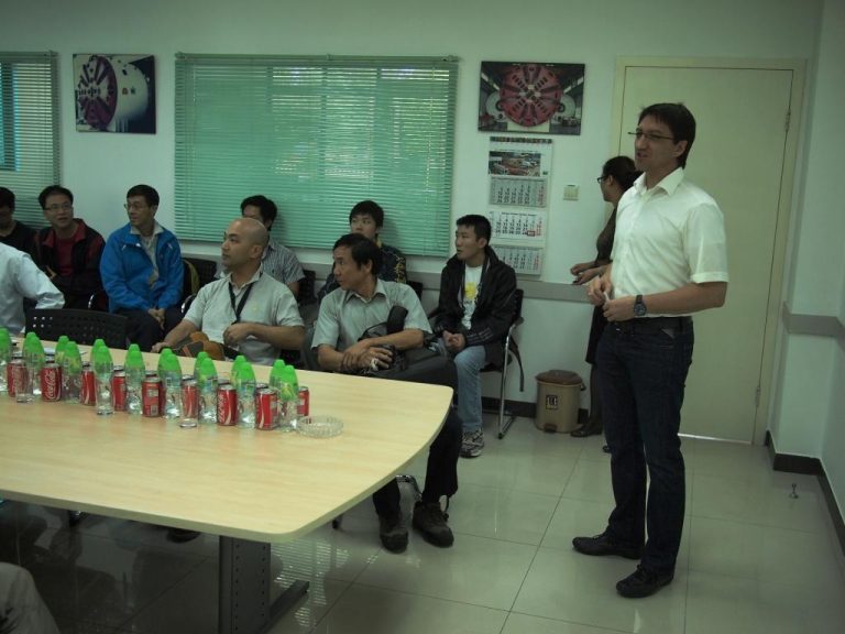 Man presenting to group in conference room with beverages on table
