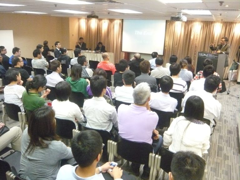 "Audience attending presentation with ""The End"" slide displayed on screen."