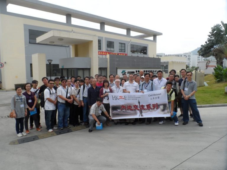Group of people posing with banner outside a modern building