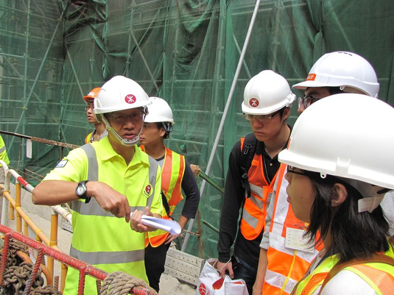 Workers in hard hats checking plans on site