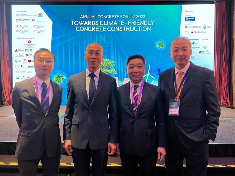 Four men in suits pose at the Annual Concrete Forum 2023 event.