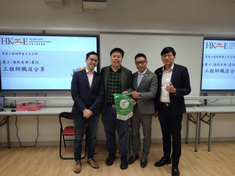Four men posing with a green flag at an HKIE engineering career sharing event.
