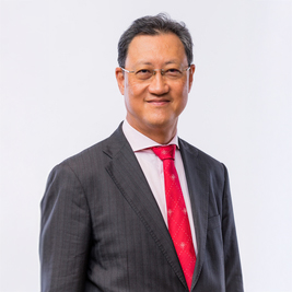 Man in suit and red tie smiling at camera