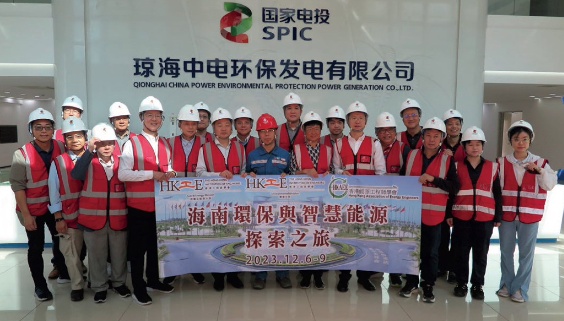 Group of engineers in hard hats and safety vests posing with a banner at SPIC facility.