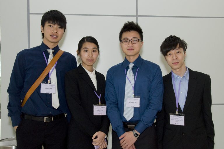 Four people in business attire with name tags at an event