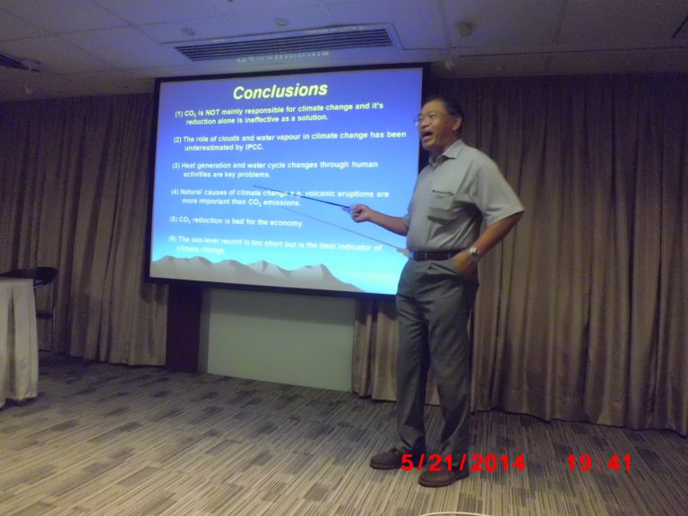 Man presenting climate change conclusions on screen using pointer.