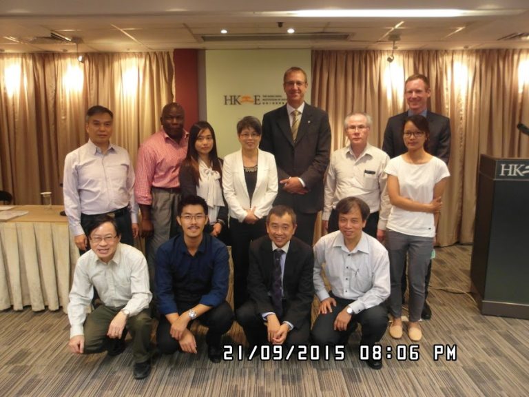 Group photo of eleven people at an event, posing in front of an HKIE banner.