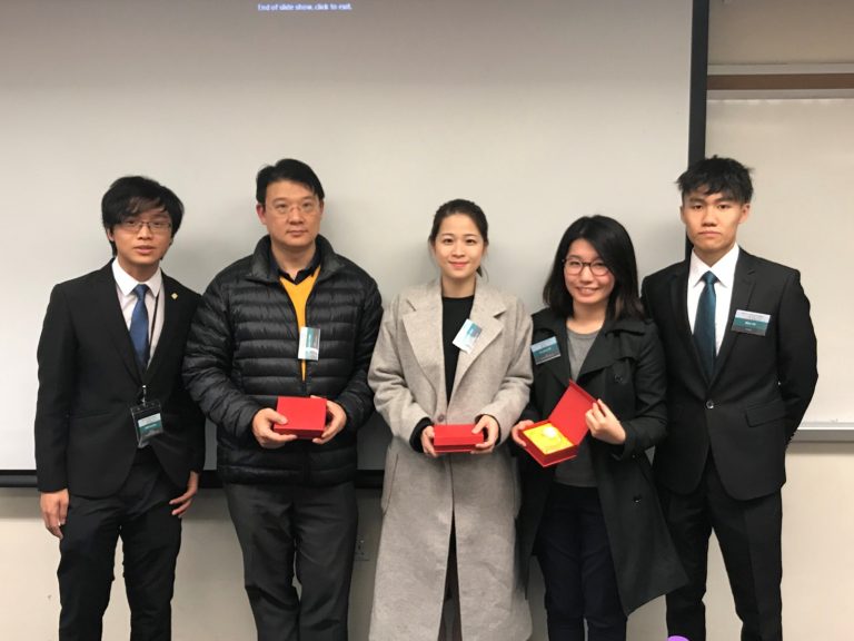 5 people with red gift boxes in front of a screen