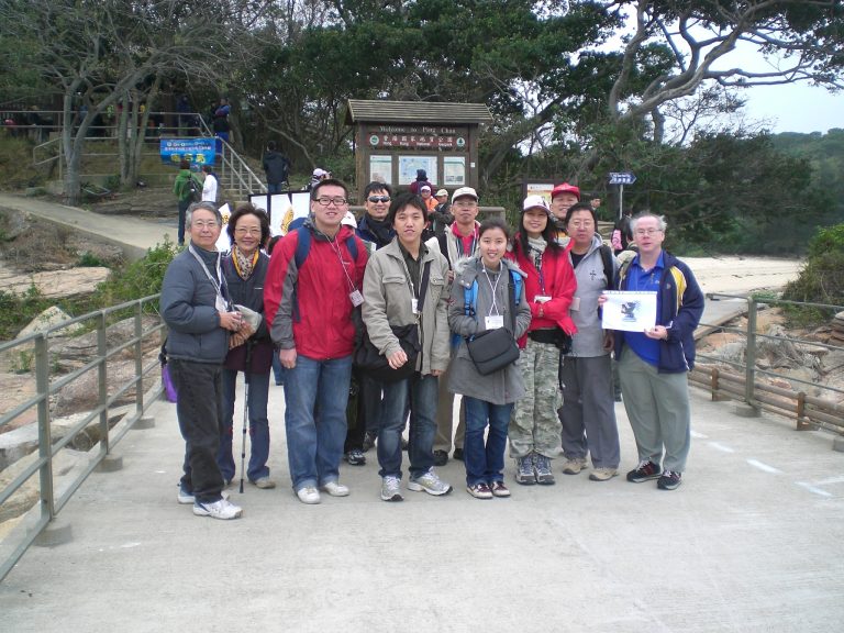 Group of people posing for photo at Ping Chau National Geopark entrance.