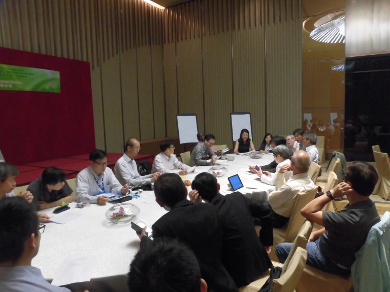 Group of people attending a meeting around a large conference table.