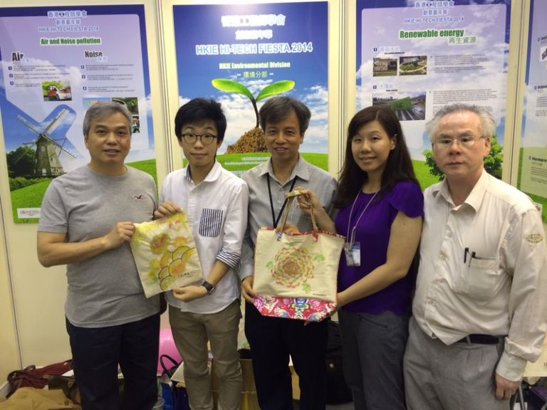 Five people posing with eco-friendly tote bags at HKIE Hi-Tech Fiesta 2014 event.