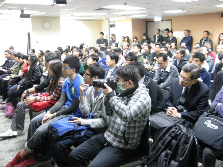 People in a room, one taking pictures