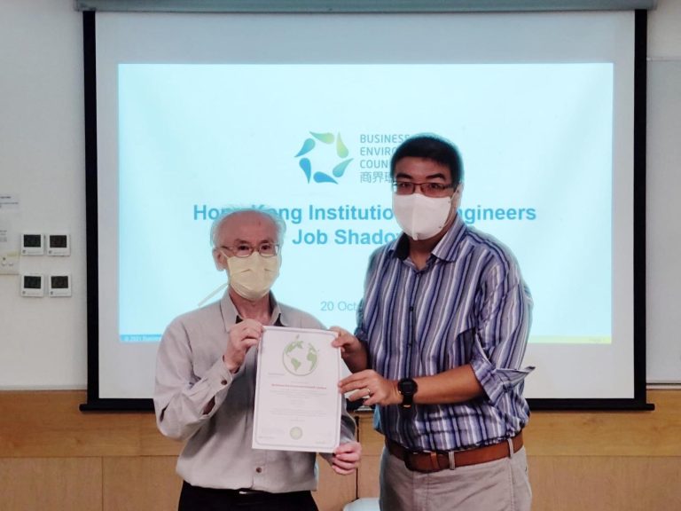 Two men in masks holding a certificate at a job shadowing event.
