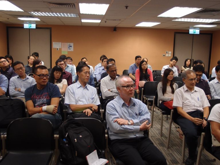 Audience seated in conference room listening attentively