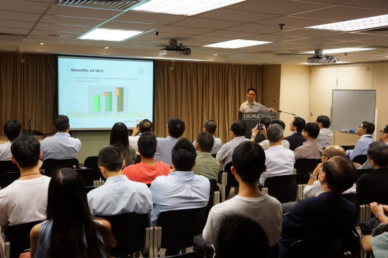 Audience attending a presentation on DCS energy savings benefits.