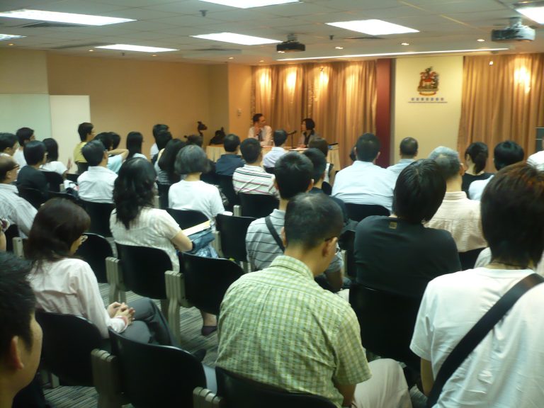 Audience seated in conference room listening to speakers at front