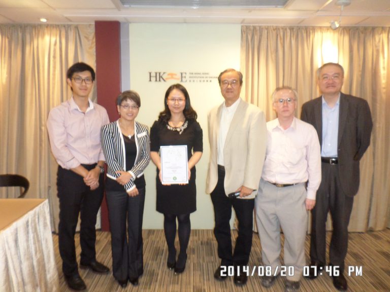 Six people pose for a photo at an event, one holding a certificate in front of an HKIE backdrop.