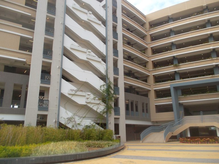 Modern multi-level building with staircases and greenery in courtyard