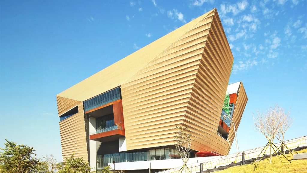 Modern architectural building with layered wooden facade under blue sky
