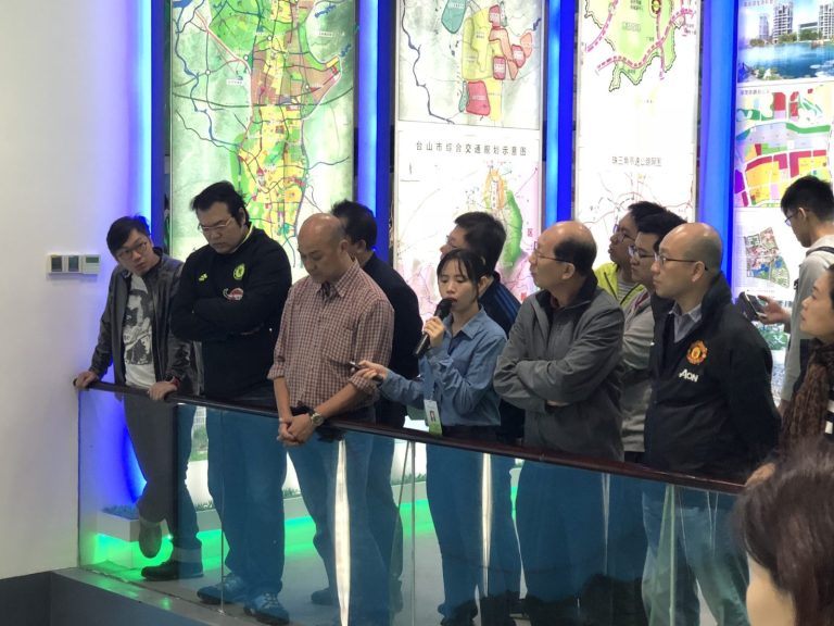 Group of people viewing large urban planning maps in an exhibition space.