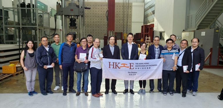 Group of engineers posing with HKIE Fire Division banner in industrial facility